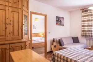 a small room with a bed and a couch at Casa Lorenz 1 in Canazei