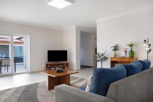 a living room with a couch and a tv at Villa Rosa com Piscina e Jacuzzi in Salir de Matos