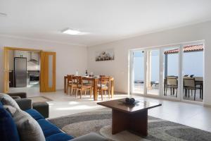 a living room with a blue couch and a table at Villa Rosa com Piscina e Jacuzzi in Salir de Matos