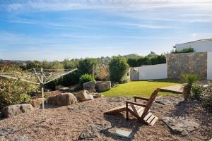 a wooden bench sitting in the middle of a garden at Villa Rosa com Piscina e Jacuzzi in Salir de Matos