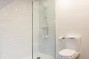 a white bathroom with a shower and a toilet at La Carbonera in Alaejos +22 photos