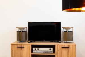 a flat screen tv on a wooden stand with two speakers at La Carbonera in Alaejos