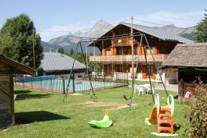 a house with a playground in front of a house at Chalet de la Marmotte in Crest-Voland