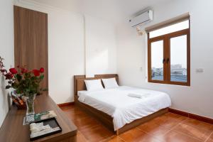 a bedroom with a bed and a table with a vase of flowers at South Star Hotel in Ninh Binh