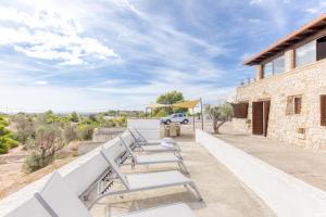 a group of benches sitting on the side of a building at Villa Liscedde Leuca in Castrignano del Capo