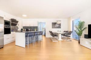 a kitchen with white cabinets and a table and chairs at Apartment-Ernst in Finsterwalde