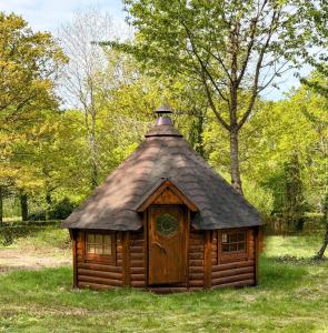 a small log cabin with a tin roof at Les cabanes de Condé in Condé-sur-Vesgre