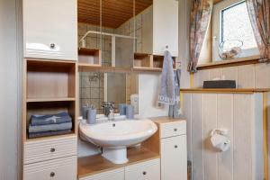 a bathroom with a sink and a mirror at Ferienwohnung Heimathafen in Lensahn +17 photos