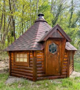 a small wooden cabin with a tin roof at Les cabanes de Condé in Condé-sur-Vesgre
