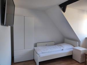 a small white bed in a white room at Hof Grübler in Klipphausen +70 photos