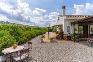a patio with a table and chairs in front of a house at Casa Villa Pinale Álora in Alora