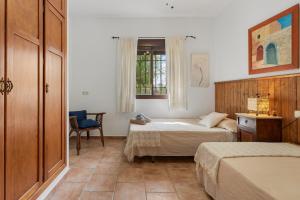 a bedroom with two beds and a chair and a window at Casa Villa Pinale Álora in Alora +19 photos