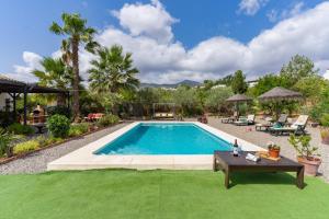 a swimming pool in a yard with a table at Casa Villa Pinale Álora in Alora