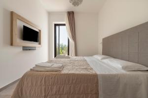 a bedroom with a large bed with a television on the wall at Tenuta Vigna Corallo - Mimosa in Otranto +17 photos