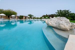 a large swimming pool with a large rock at Tenuta Vigna Corallo - Mimosa in Otranto
