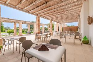 a patio with tables and chairs on a patio at Tenuta Vigna Corallo - Mimosa in Otranto