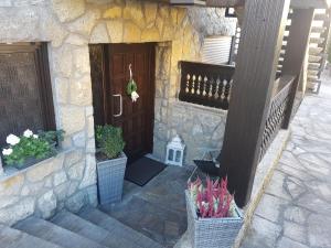 a stone building with a door and two potted plants at Ferienwohnung Reblaus in Markt Einersheim