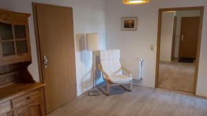 a white chair sitting in a room next to a door at Das Landhaus Wohnung 1 in Kirch Mulsow
