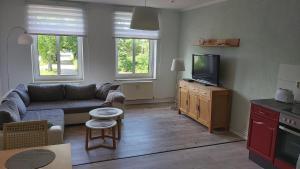 a living room with a couch and a tv at Das Landhaus Wohnung 1 in Kirch Mulsow