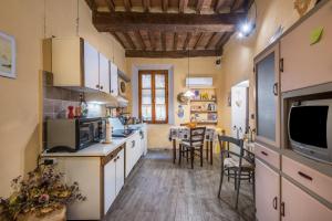 a kitchen with white cabinets and a table with chairs at La Casa Gialla di Buonconvento in Buonconvento