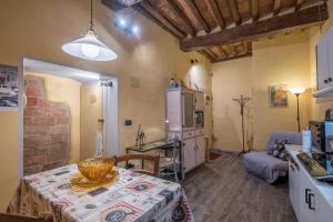a room with a table and a kitchen with a refrigerator at La Casa Gialla di Buonconvento in Buonconvento