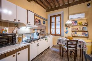 a kitchen with white cabinets and a table in it at La Casa Gialla di Buonconvento in Buonconvento +13 photos