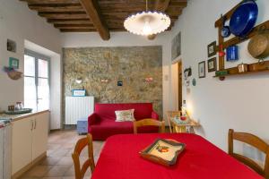 a living room with a red table and a red couch at Casa Pel di Lupo in Rosignano Marittimo