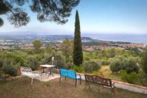 three chairs and a table with a view of the ocean at Casa Pel di Lupo in Rosignano Marittimo