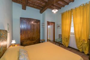 a bedroom with a yellow bed and yellow curtains at Casa Pel di Lupo in Rosignano Marittimo