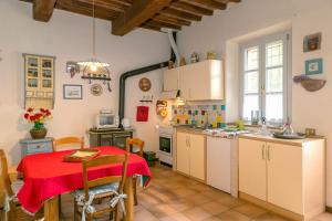 a kitchen with a table and a red table cloth at Casa Pel di Lupo in Rosignano Marittimo +22 photos