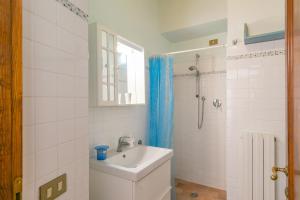 a white bathroom with a sink and a shower at Casa Pel di Lupo in Rosignano Marittimo