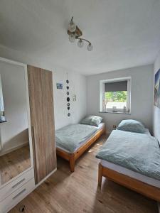 a bedroom with two beds and a window at Auszeit zwischen Fellnasen in Bischofsgrün