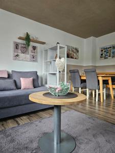 a living room with a blue couch and a table at Auszeit zwischen Fellnasen in Bischofsgrün