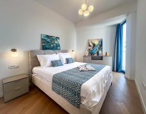 a bedroom with a large bed with blue and white sheets at Sobre Suites in Bečići +41 photos