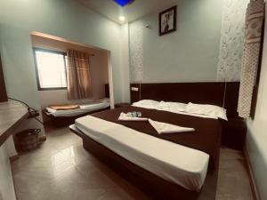 a hotel room with two beds and a window at Bbhakt niwas in Tuljapur