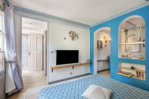 a blue bedroom with a bed and a tv at Sous L'olivier in Menton +51 photos