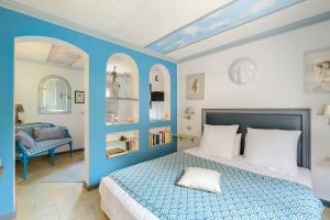 a blue bedroom with a bed and a chair at Sous L'olivier in Menton
