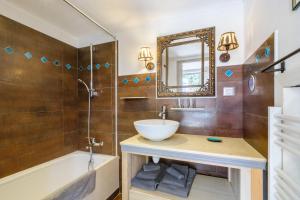 a bathroom with a sink and a tub and a mirror at Sous L'olivier in Menton
