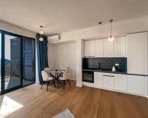 a kitchen and dining room with a table and chairs at Sobre Suites in Bečići
