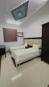 a hotel room with two beds and a board on the ceiling at شقق مخدومه in Najran