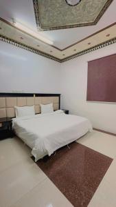 a bedroom with a large white bed in a room at شقق مخدومه in Najran