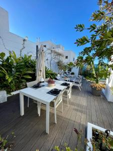 a white table with chairs and an umbrella on a deck at El Escondrijo Ibiza in San Antonio