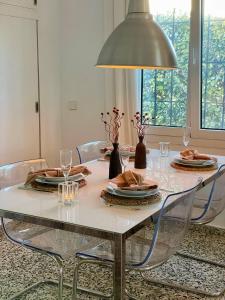 a dining room table with chairs and a large light fixture at El Escondrijo Ibiza in San Antonio