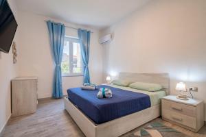 a bedroom with a bed with blue sheets and a window at Thomas' House in Alghero