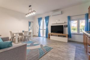 a living room with a couch and a table with a television at Thomas' House in Alghero