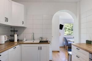 a kitchen with white cabinets and an archway at Ferienwohnung Kleinbreitenbach in Plaue