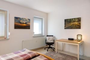 a bedroom with a desk and a bed and a table at Ferienwohnung Kleinbreitenbach in Plaue