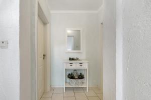 a white hallway with a white table and a mirror at Ferienwohnungen Golsong in Thaleischweiler-Fröschen +54 photos