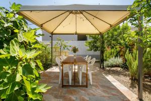 a wooden table and chairs under an umbrella at Chez Martine Tenerife in Granadilla de Abona