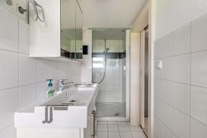 a white bathroom with a sink and a shower at Mein Haus in Pellworm +38 photos